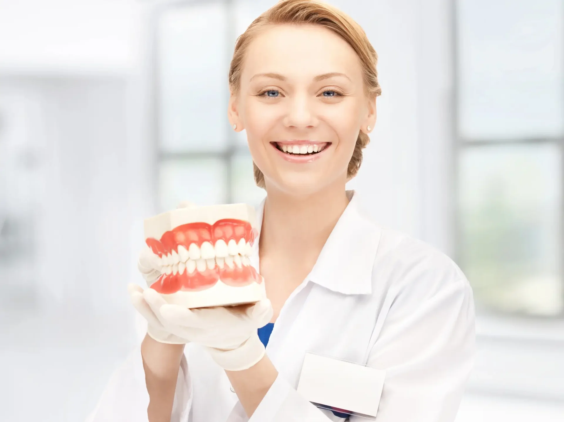 Doctor holding jaw model showing custom dentures Farmington Hills MI